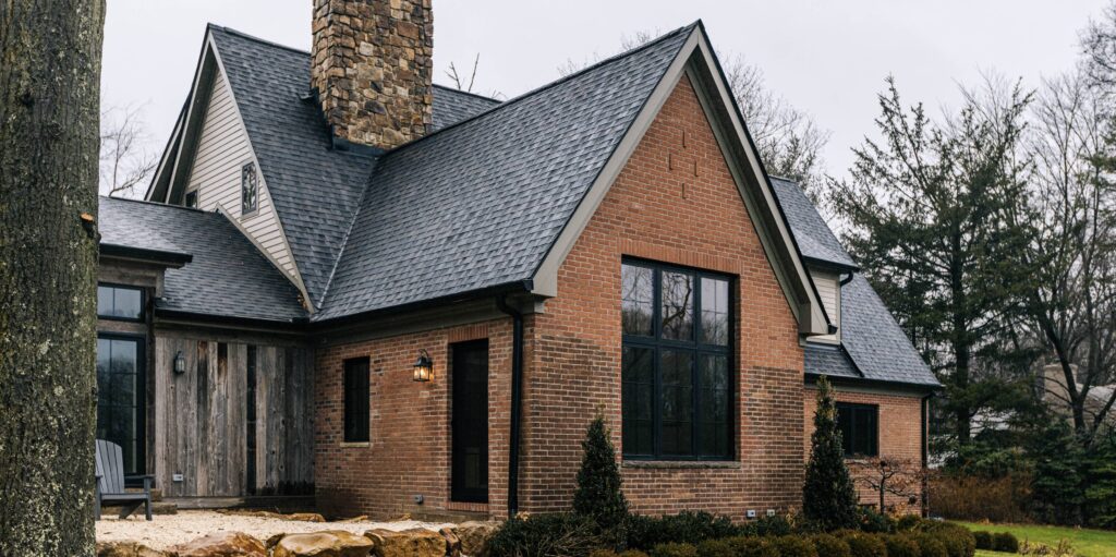 Side view of a custom home with a large bay window and slanted roof.