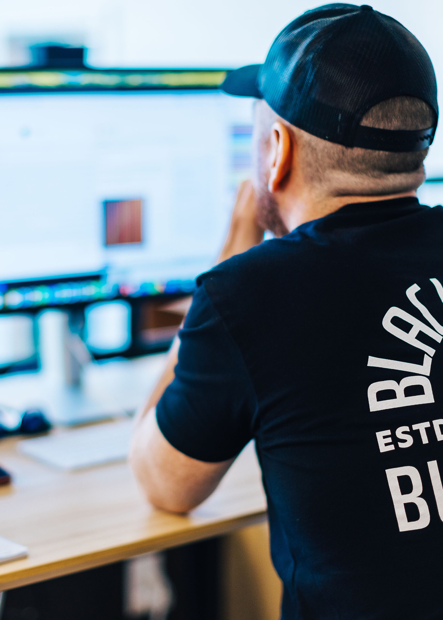 Black Boot Builder employee looking at computer.