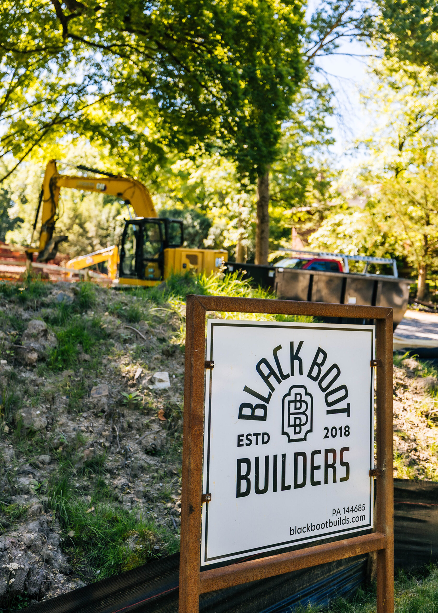 Black Boot Builders sign posted outside custom home site preparation area.